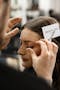 Servilles Academy makeup student applies eyelashes onto model